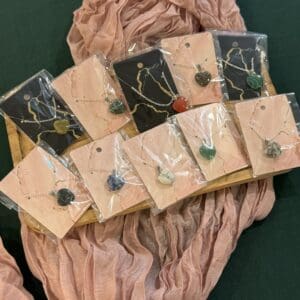 A bunch of necklaces that are on some pink fabric