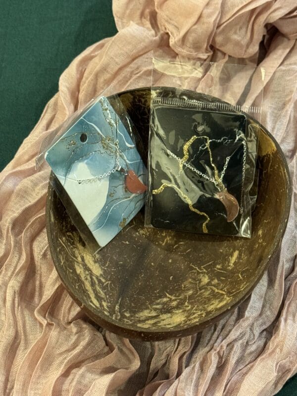 A bowl of gold and black marble on top of cloth.