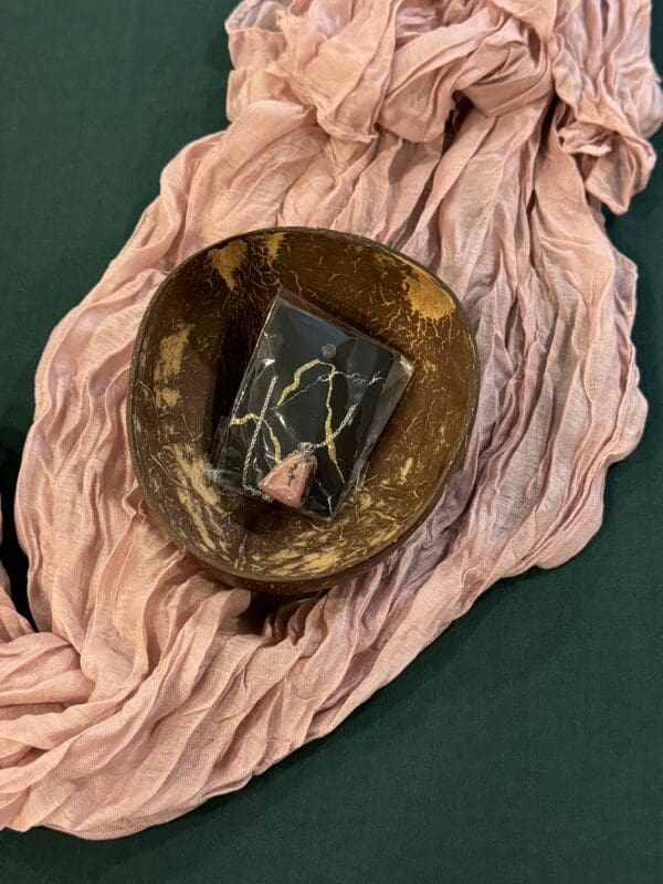 A bowl and plate on top of pink fabric.