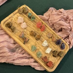 A wooden tray with many different colored stones on it.