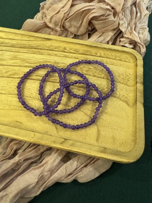 A yellow tray with purple beads on top of it.