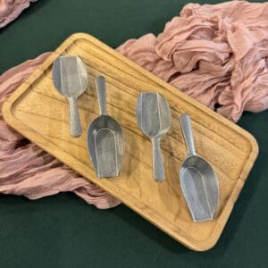 A wooden tray with four spoons on it.